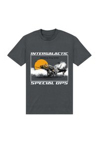 T-shirt grigio scuro con una grafica di un'astronave, testo bianco e nero che recita "Intergalactic Special Ops", con un sole giallo sullo sfondo.