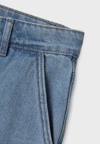 Gai zili džinsi ar taisnu griezumu, kas satur plecu priekšpusi, redzamus diegu šuves un klasisku jostas dizainu.