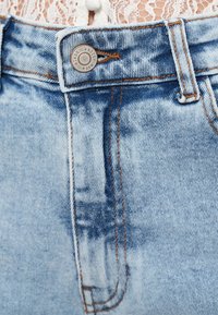 Világoskék magas derekú farmer rövidnadrág, kontrasztos narancssárga varrással és márkázott fém gombbal a derékrészen.