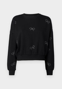 Černá dlouhá tillie s cropped střihem, s žebrovanými manžetami a lemem, zdobená malými stříbrnými kamínkovými mašlemi rozptýlenými po přední části a rukávech.