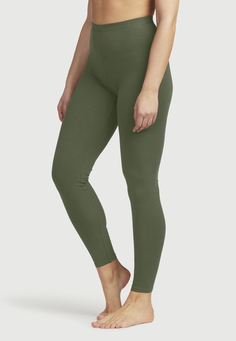 Oliivivihreät legginsit joustavasta kankaasta, joissa on korkea vyötärö ja slim fit -silhuetti, sileä rakenne ilman näkyviä saumoja.