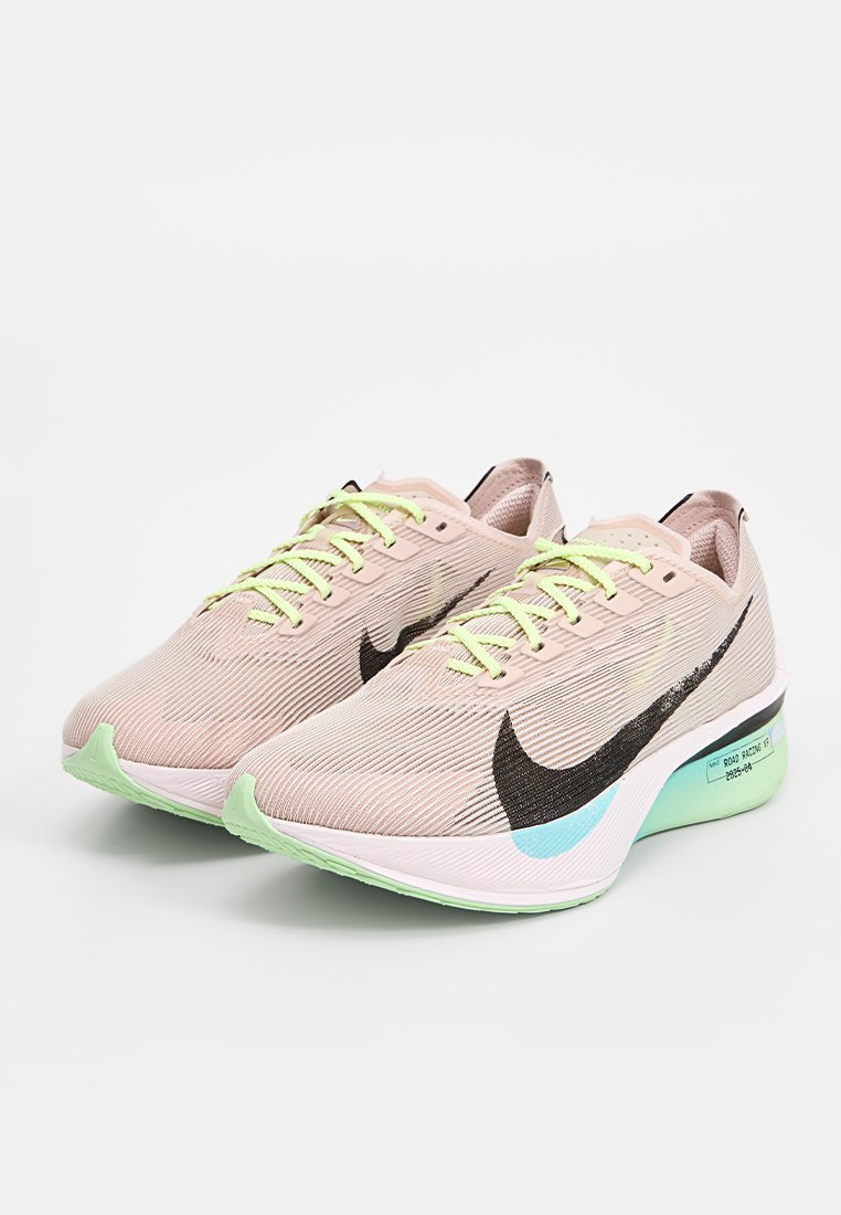 Zapatillas de correr rosa claro con parte superior texturizada, logo Swoosh negro, cordones verde neón y suela verde menta con detalles en azul.