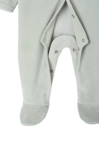 Helles, graues Baby-Einteiler mit Druckknöpfen an den Beinen und Fußbedeckung, vor einem weißen Hintergrund präsentiert.