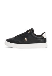 Sneaker in pelle nera con suola in gomma bianca, dotati di lacci neri, un emblema dorato e un accentuazione bianca a contrasto sul tallone.
