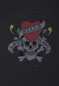 Černá látka obsahuje barevný grafický design se skullem, srdcem a bannerem s nápisy "LÁSKA ZABIJE POMALU" a "Los Angeles", zdobený rhinestones.