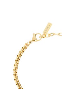 Zlatý náramek s proplétaným designem, s karabinovým zapínáním a štítkem s vyrytým nápisem "BREIL". Hladký a lesklý povrch.