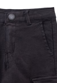Zwarte denim pantalons met knoopsluiting, twee voorzakken en een zijzak, van textuurstof met contrasterende stiksels.