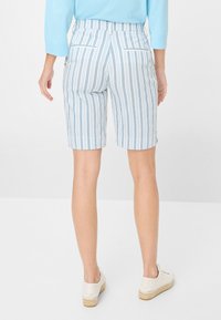 Shorts rayés bleu et blanc avec une texture lisse, présentant une taille mi-haute, des poches latérales et une coupe droite au-dessus du genou.