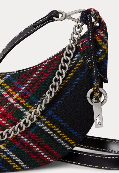 Kockás kézitáska, amelynek domináns fekete színe van, piros, zöld és sárga mintákkal. Ezüst lánccal és bőrpánttal díszítve.
