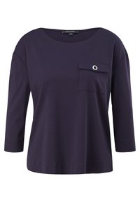 Haut bleu marine pour femme avec manches trois-quarts, col rond et poche poitrine avec rabat et œillet métallique.