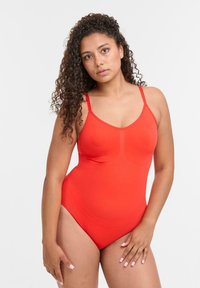 Roter Badeanzug mit dünnen Trägern, nahtlosem Design und glatter Textur. Verfügt über einen Scoop-Ausschnitt und einen hochgeschnittenen Beinausschnitt.