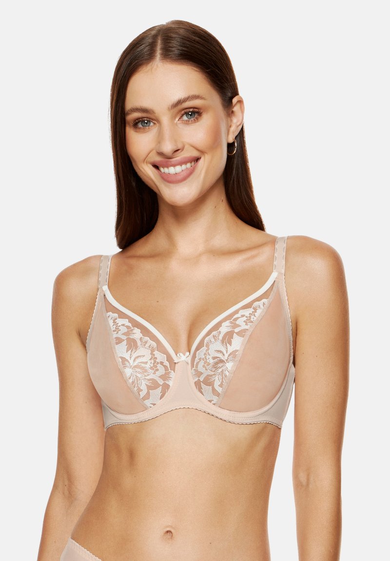 Nude bezprzewodowy stanik z przezroczystymi koronkowymi miseczkami w kwiatowy wzór, z miękkim podszyciem i delikatnym białym wykończeniem na brzegach i ramiączkach.