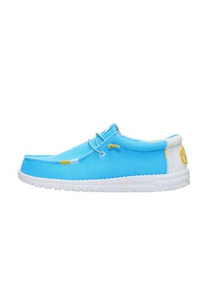 Scarpa slip-on casual azzurro chiaro con suola bianca a macchie, dettagli con cuciture gialle e dettaglio bianco sul tallone, vista di lato su sfondo bianco.