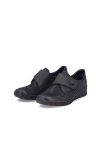 Paire de chaussures slip-on en cuir noir avec motif texturé et large bride ajustable sur le dessus, semelle compensée basse et bout arrondi.