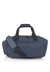 Bolsa de deporte azul marino hecha de tejido duradero, con cierre de cremallera, asas cortas y una correa de hombro desmontable con un logo visible.
