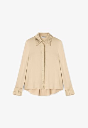 Beige košile s dlouhými rukávy a č butiky na límečku a manžetách. Hladká tkanina, volný střih, měděné nýty podél švů a zaoblený lem.