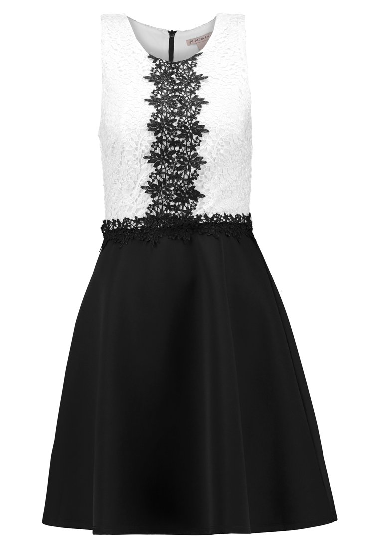 Schwarz-weißer Kleid mit einem strukturierten Spitzenoberteil, einem floralen Spitzenakzent und einem ausgestellten schwarzen Rock. Reißverschlussverschluss auf der Rückseite.