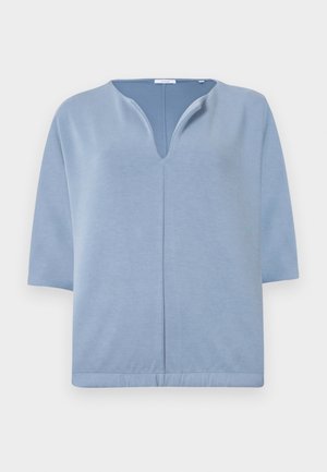 Svijetloplava majica kratkih rukava s V-izrezom i bešavnim dizajnom. Izrađena od mekog materijala s blagom teksturom i opuštenim krojem.