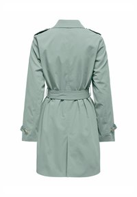 Trench-coat vert clair, en tissu lisse. Doté d'une taille ceinturée, de manches longues, de boutons aux poignets et d'un col classique.