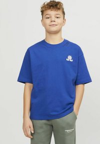 Blauwe T-shirt met korte mouwen van katoen met een ronde hals. Bevat een wit logo op de borst en decoratieve tekst nabij de kraag.