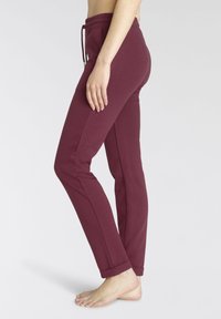 Bordeauxfarbene Jogginghose aus weichem Baumwollmix; mit elastischem Bund und Kordelzug, schmal zulaufenden Beinen und Bündchen am Saum.