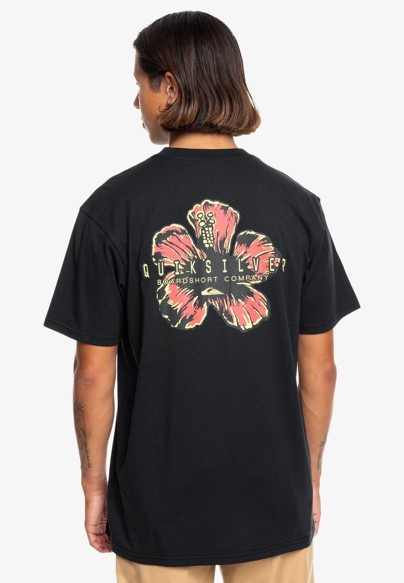 Mustapaita lyhyillä hihoilla, jossa on suuri vaaleanpunainen hibiskuskuvio selässä ja keltainen teksti 'Quiksilver Boardshort Company'.