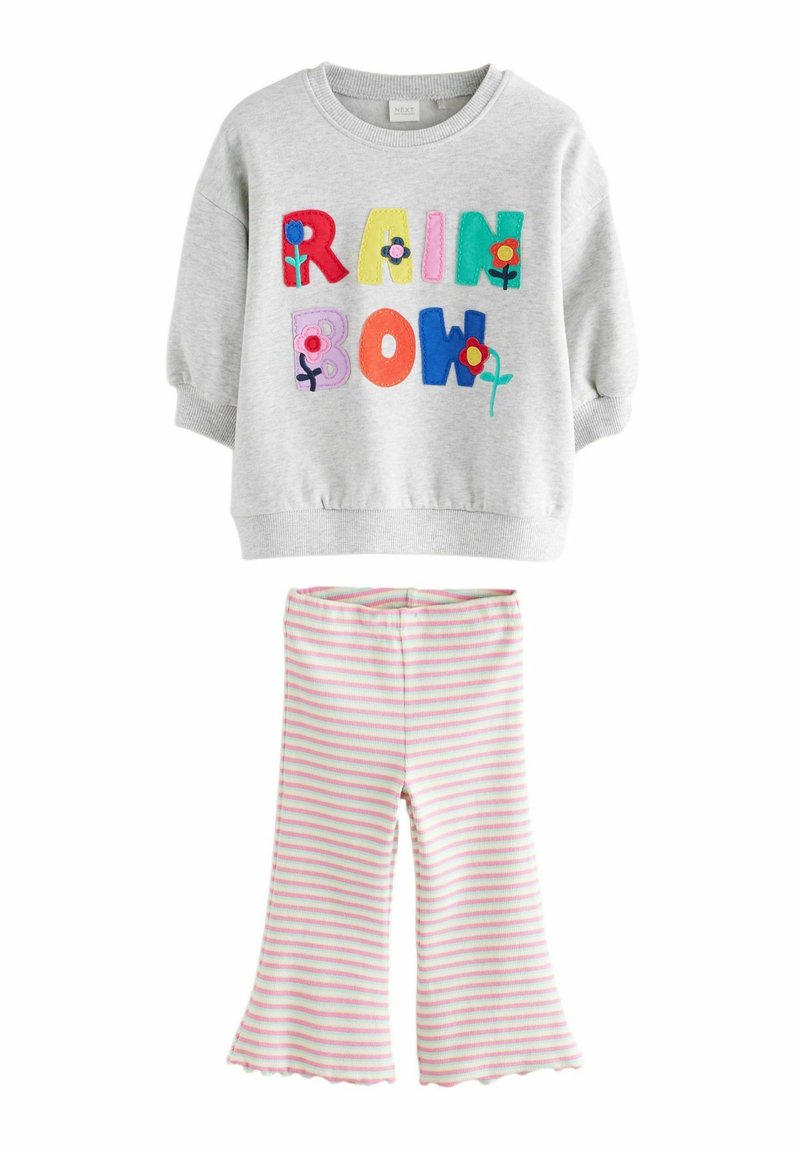 Grauer Sweatshirt mit buntem "RAINBOW"-Text und floralen Akzenten; kombiniert mit gestreiften Schlaghosen in Pink und Weiß.