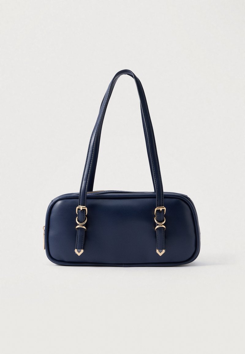 Tummansininen käsilaukku, jossa on tyylikäs suorakulmainen muoto. Valmistettu sileästä materiaalista, jossa on kultaiset yksityiskohdat ja kaksi pitkää olkainta.