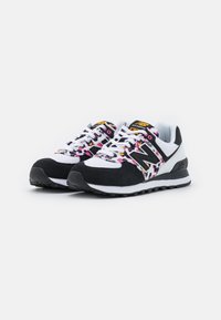 Baskets noires et blanches en matériaux suède et mesh. Dotées d'un motif floral coloré, d'un logo "N" bien visible, et d'une semelle en caoutchouc antidérapante.