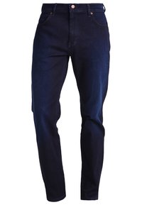 Mörkblå denimjeans med smal passform, klassisk design med fem fickor, kopparnitar och en subtil textur. Har raka ben och midjeband.