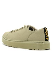 Sneaker in tela beige con punta arrotondata, design a lacci piatti, suola in gomma testurizzata e un accento nero sul tallone con branding giallo.