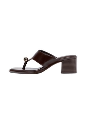 Sandale mule marron foncé à bout ouvert avec talon bloc, large bride et ornement rond métallique sur la bride d’orteil.
