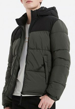 Veste rembourrée de couleur vert foncé et noir, dotée d'une fermeture éclair, d'une capuche et de poignets élastiques. Le matériau est lisse avec une texture matelassée.