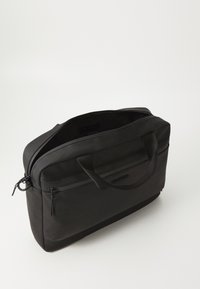 Crna torba za laptop s glatkom teksturom, zatvorenim pregradama, dvostrukim ručkama i minimalističkim dizajnom. Sadrži logo urezan na prednjoj strani.