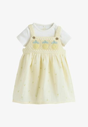 Babykleid in Cremefarbe mit kurzen Ärmeln, gestrickten oberen Trägern und Zitronenstickerei auf Brust und Rock.