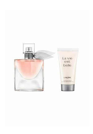 Gennemsigtig rektangulær parfume flaske med en sølvsløjfe, indeholdende lys pink væske, placeret ved siden af en hvid bodylotion tube med etiketten "La vie est belle."