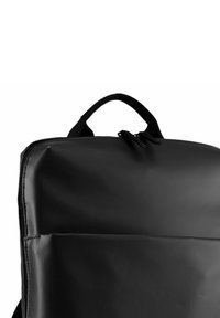 Mochila negra hecha de material liso y duradero, con un asa superior y cierre de doble cremallera. Forma rectangular sin patrones visibles.