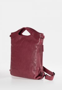 Bordeaux leren tote bag met een gladde textuur, voorzien van dubbele handvaten en een afneembare schouderband. Compact ontwerp met minimale stikseldetails.