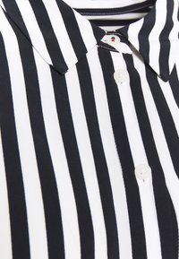 Zwart-wit gestreepte shirt met een ontwerp met kraag, knoopsluiting en een gladde textuur. Verticale strepen, standaard pasvorm.