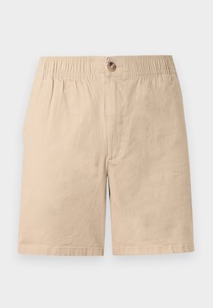 Shorts à taille élastique beige avec fermeture à bouton, coupe droite et design uni, présentés sur fond blanc.