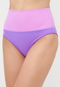 Augstās jostas vietas sieviešu bikini apakšdaļa ar krāsu bloku dizainu - gaiši rozā augšdaļa un lavandas purpursarkana apakšdaļa, kas kontrastē ar ādas toņa kājām.
