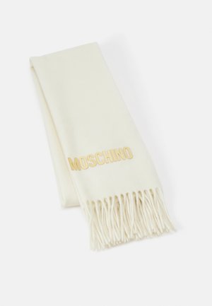 Écharpe en laine couleur crème avec extrémités à franges, pliée soigneusement, arborant les lettres du logo MOSCHINO en or d'un côté.