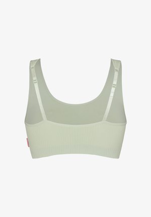Lichtgroene naadloze bralette met verstelbare schouderbandjes en geribbelde elastische band, gezien vanaf de achterkant tegen een witte achtergrond.