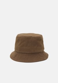 Brun bomullsbøttehatt med bred kant, strukturert krone og vertikal sømdetaljering langs sidene. Glatt tekstur, uformelt design.