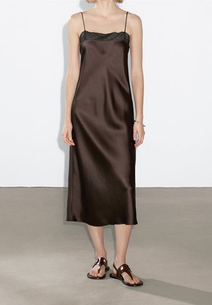 Brown satin slip dress with thin straps and a black lace top, featuring a straight silhouette that falls just below the knee.