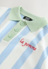 Stribet polo i hvid og lyseblå med grøn krave, der har tre grønne knapper og rødt broderet tekst "la pomme".