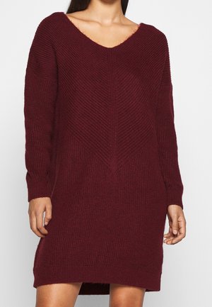 Abito in maglia bordeaux con scollo a V, maniche lunghe e un motivo testurizzato. Presenta una vestibilità ampia con orlo dritto e spacchi laterali.