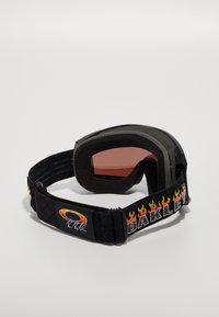 Slidiniai akiniai su juodu dirželiu, puoštu liepsnos raštu, pilku putų rėmeliu ir rožinėmis lęšiais. Dirželio viduryje matomas "Oakley" logotipas.
