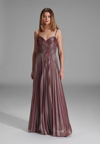 Pitkä, poimutettu mekko syvässä vaaleanpunaisessa sävyssä, jossa on sydänmainen kaula-aukko. Kankaan pinnassa on hienovarainen kimalle, joka korostaa sen virtaavaa muotoa ja eleganttia siluettia.