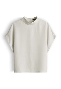 Blusa beige a maniche corte con collo alto e chiusura con cerniera sul retro, mostrata su sfondo bianco.